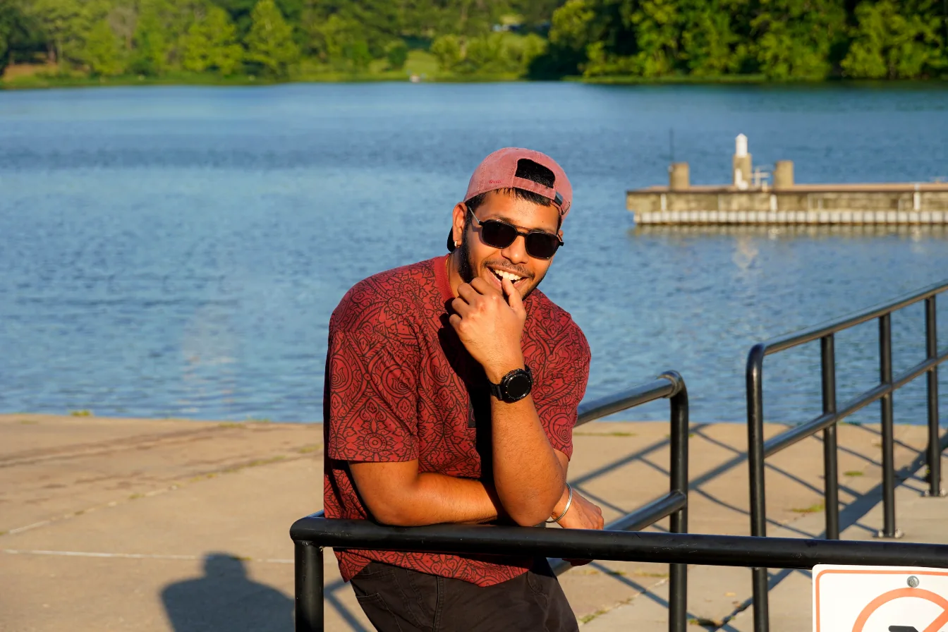 Tejesh smiling beside a lake